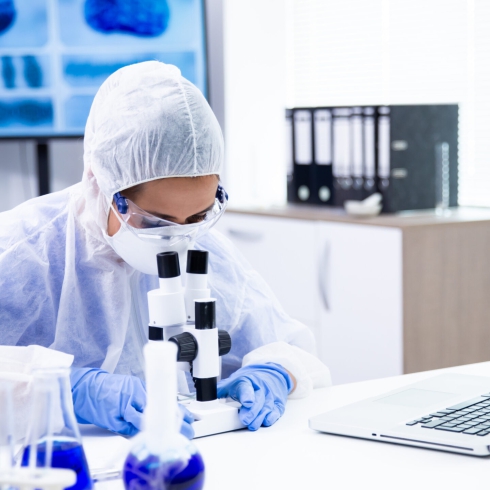 Caucasian chemist is watching a reaction under the microscope. Pharmaceutical research